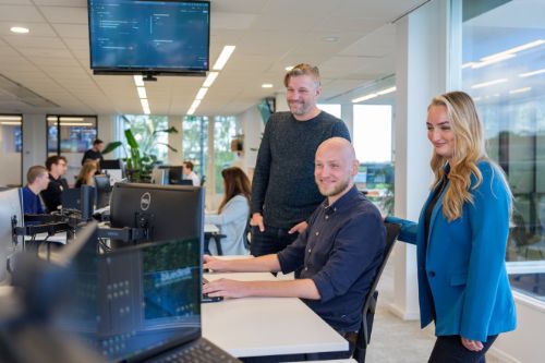 Man en vrouw werken samen aan digitale strategie bij Bluedesk op een open kantoorvloer.